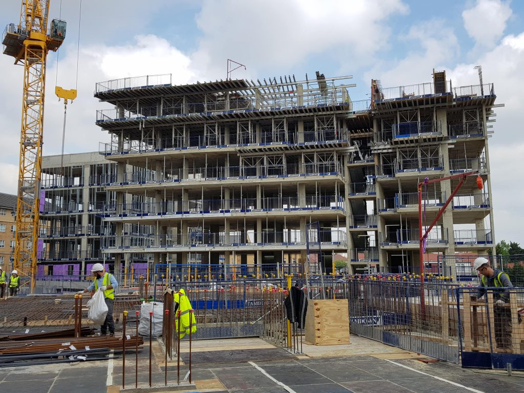 Construction site of a multi story building, workers are performing duties around the site used on a blog post for construction growth