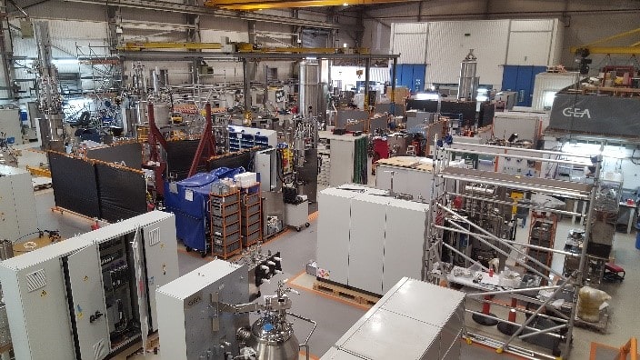 Interior view of the European Skid Centre (ESC) showcasing industrial process equipment, control panels, and machinery assembly stations in a manufacturing facility.