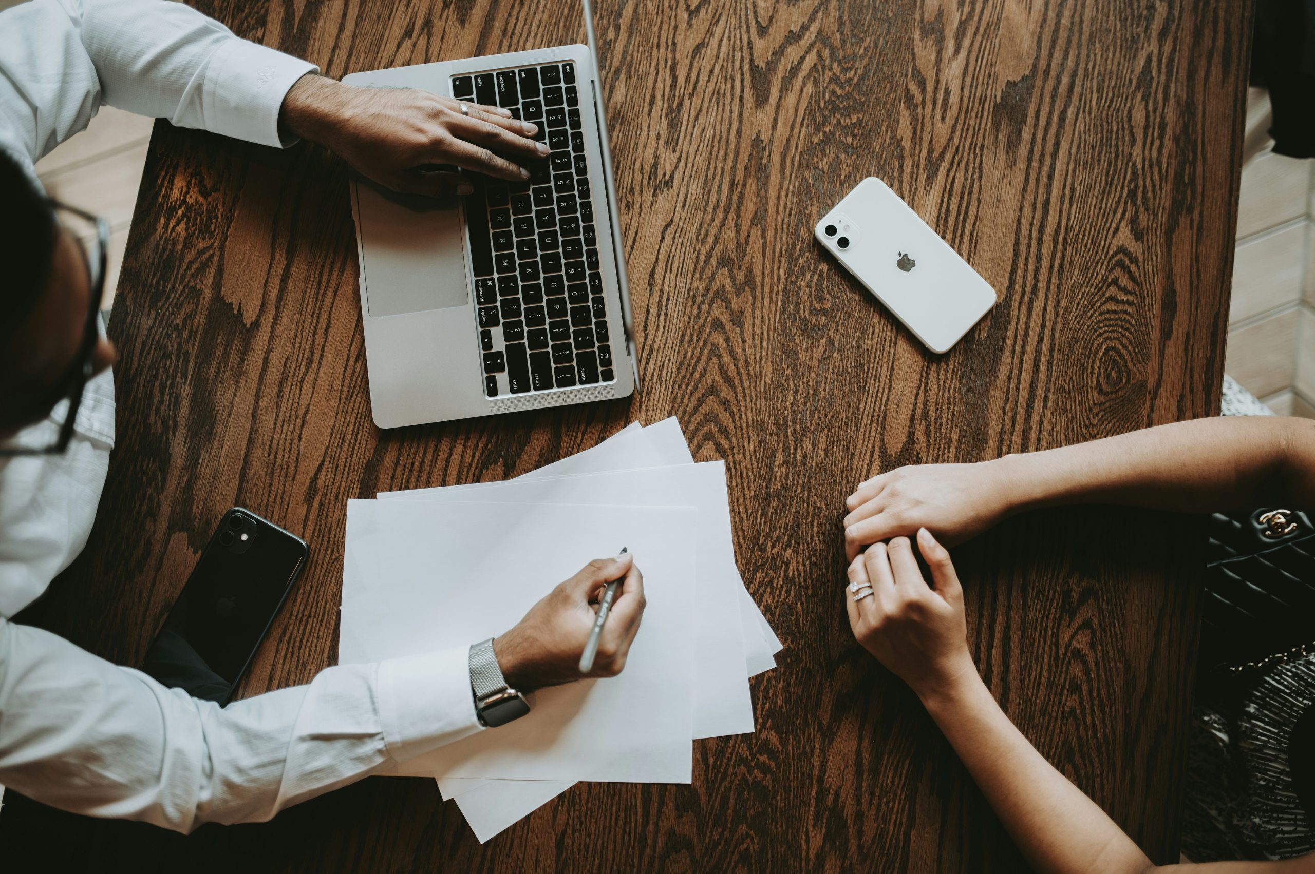 meeting taking place on a wooden desk one on a laptop